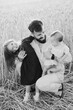 © Ananass - Happy young father in the arms of his little daughters. Dad and 2 daughters are photographed in the field, a happy Ukrainian family