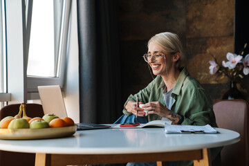 Wall Mural - Middle aged blonde woman with short hair studying