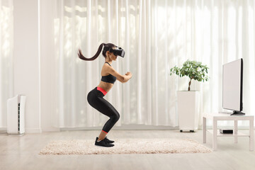 Wall Mural - Full length profile shot of a young woman exercising with a vr headset in front of tv