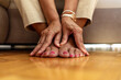 © Jelena Stanojkovic - Close up of senior woman hands touching legs with varicose veins, sitting on sofa at home. Woman suffering from ankle pain. An older woman massages her feet to relieve the pain caused by rheumatism.