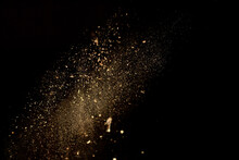 Dust And Wood Chips On A Black Background. Dirt Particles Fly In The Air. Layout For Design. Some Dust Particles Are Blurred To Transmit The Effect Of Motion.