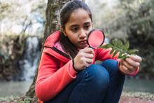 Girl With Leaf Looking Through Loupe In Forest