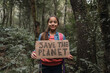 © ADDICTIVE STOCK - Ethnic girl showing Save The Planet title in summer woods