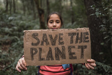 Ethnic Girl Showing Save The Planet Title In Summer Woods