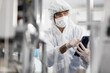 © offsuperphoto - male engineers wearing personal protective equipment uniform(PPE) using tablet and checking medical face mask beside machine in laboratory