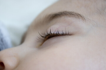 close-up photo of a sleeping kid, space for text. Concept: peaceful sleep eyelashes in focus. 