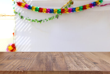 Wall Mural - Jewish festival of Sukkot. Traditional succah (hut) with decorations. Empty wooden old table for product display and presentation.