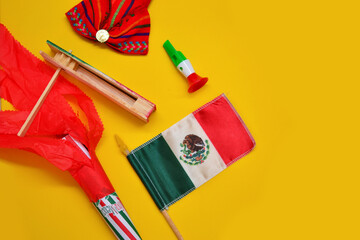 Decoration of independence day with Mexican flags, whistle of colors, rattle, folklore ribbon and cornet decorated.