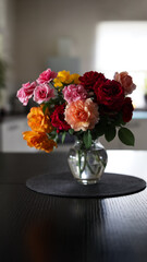 Wall Mural - Beautiful bouquet of colorful roses in glass vase on table in home interior.