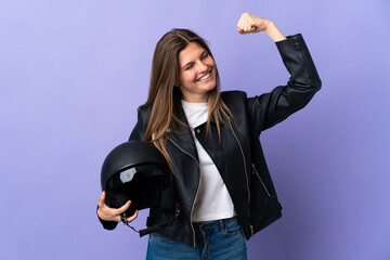 Young slovak woman holding a motorcycle helmet isolated on purple background celebrating a victory