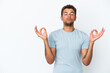© luismolinero - Young handsome Brazilian man isolated on white background in zen pose