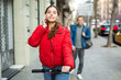 © JackF - Attractive girl in red jacket standing with bicycle outdoors and talking on a mobyle phone