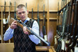 © JackF - Buyer selects a combat rifle at a gun store
