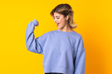 Young Russian woman isolated on yellow background doing strong gesture