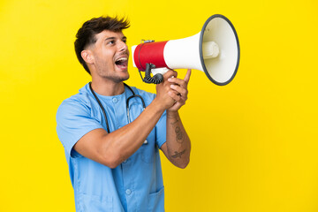 Wall Mural - Young surgeon doctor man isolated on yellow background shouting through a megaphone