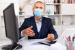 © JackF - Young man in medical mask with hand extended to handshake in office