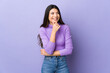 © luismolinero - Young brunette woman over isolated purple background looking to the side and smiling
