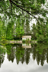 Canvas Print - Vertical shot of a lodge standing on the side of a lake surrounded by trees