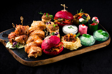 Poster - set of food on a wooden tray, a burger and snacks on a dark background