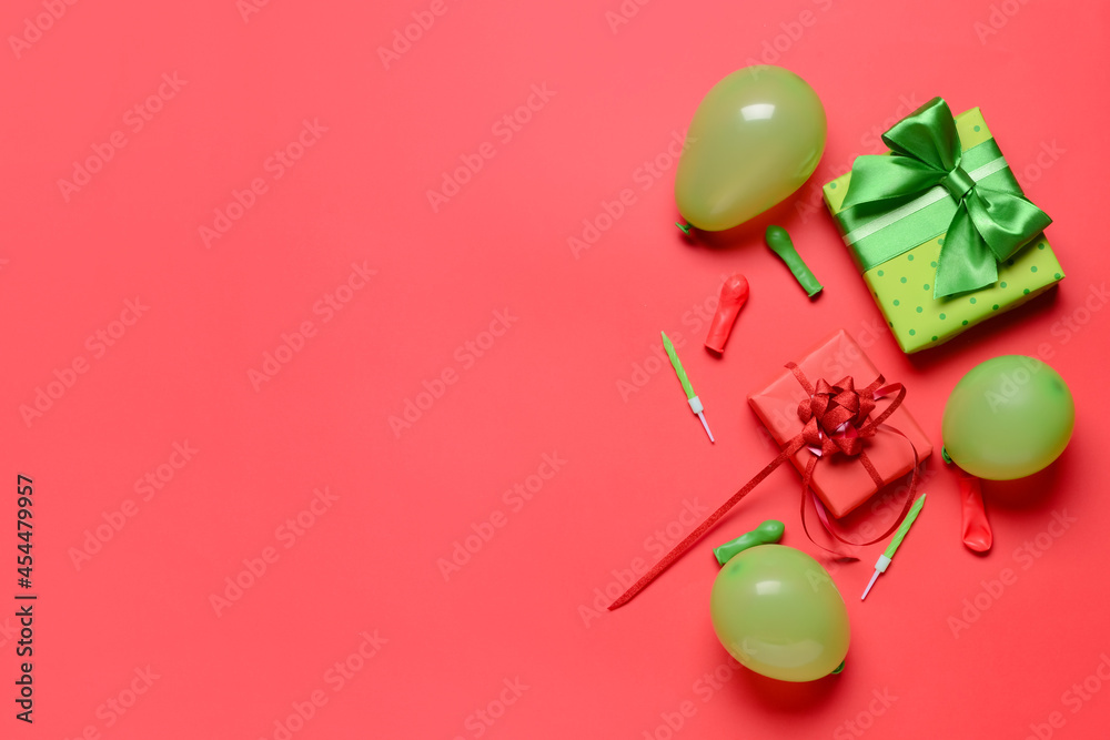 Gift boxes, balloons and candles on color background