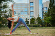 © bernardbodo - Young woman practicing stretching exercises in the park