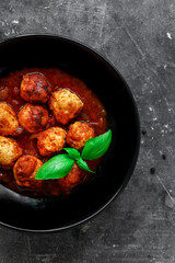 Wall Mural - Chicken meatballs with basil and tomato sauce. Dark background. Copyspace. Meatballs with tomato and chili. Top view