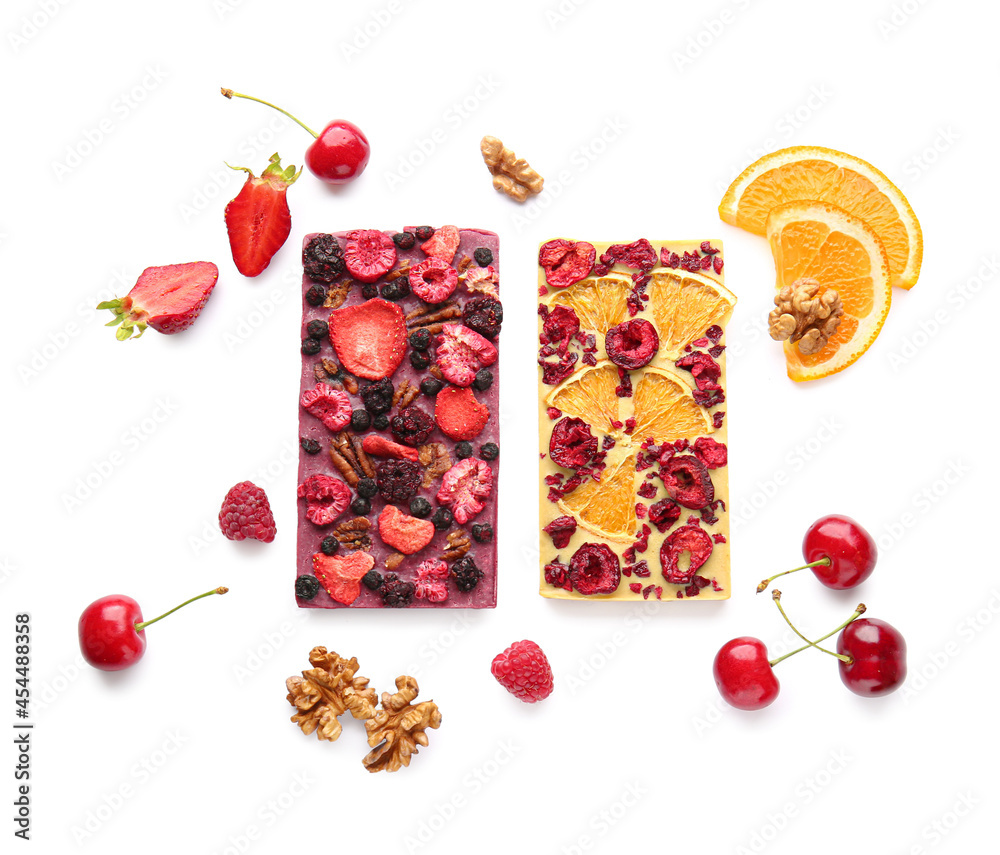 Handmade chocolate bars with fruits, berries and nuts on white background