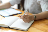 Fototapeta  - Close up, Businesswoman writing on notebook, taking notes, organising agenda