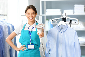 Canvas Print - Female worker with steamer at modern dry-cleaner's