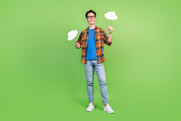 Canvas Print - Full length photo of funky brunet young guy hold look clouds wear shirt jeans sneakers isolated on green background