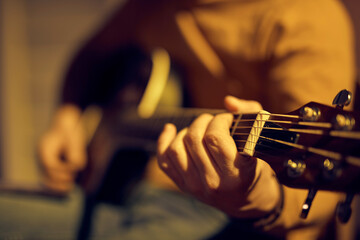 Wall Mural - Male musician playing acoustic guitar on the amplifier in retro vintage room.