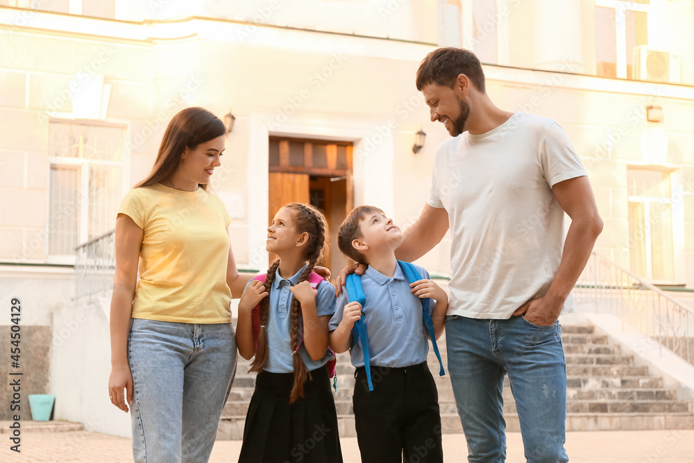 Cute little children going to school with their parents