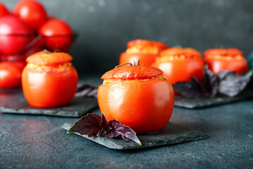 Tasty stuffed tomatoes on dark background