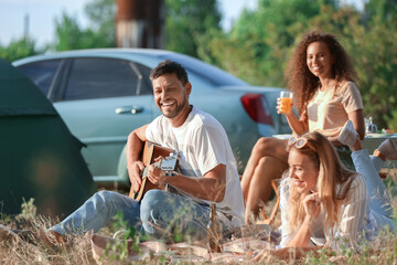 Poster - Young man playing guitar at barbecue party on summer day