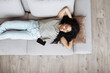 © kite_rin - Young woman relaxing at home lying on sofa. African american girl resting in her room. Enjoy life, rest, relaxation, wellbeing, lifestyle, people, recreation concept