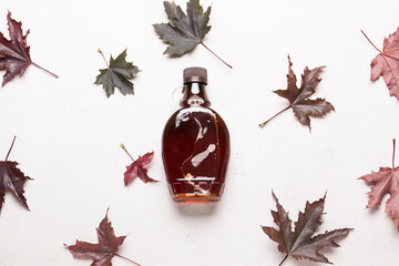 Wall Mural - Beautiful maple syrup in a bottle. Maple leaves
