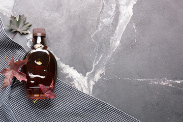 Wall Mural - Canadian maple syrup in a bottle on a dark background.