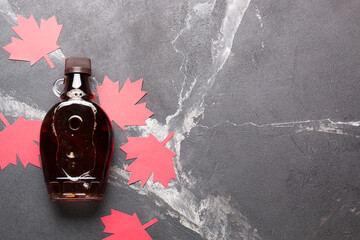 Wall Mural - Canadian maple syrup in a bottle on a dark background.