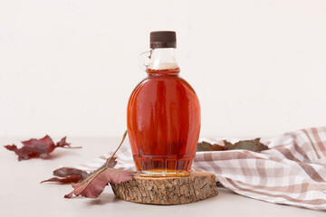 Wall Mural - Beautiful maple syrup in a bottle. Maple leaves
