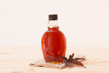 Wall Mural - Beautiful maple syrup in a bottle. Maple leaves

