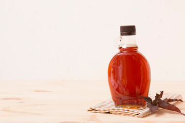Wall Mural - Beautiful maple syrup in a bottle. Maple leaves
