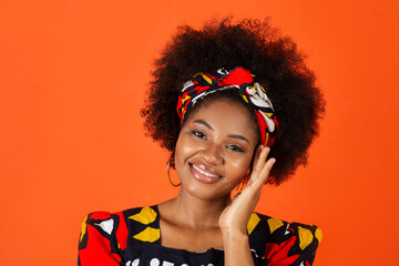 Wall Mural - cute african young woman in traditional dress on red background 