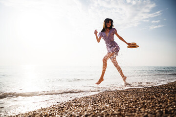 Portrait of young woman walking on the beach on sunrise