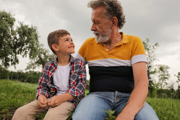 Poster - Cute little boy and grandfather spending time together in park