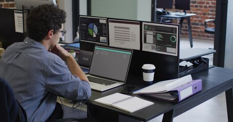 Poster - Caucasian man sitting at desk coding data on laptop