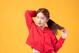 Fototapeta Tęcza - Portrait of beautiful young Asian girl model long hair in red coat summer clothes feeling smile, happy and enjoying in studio isolated on yellow background.