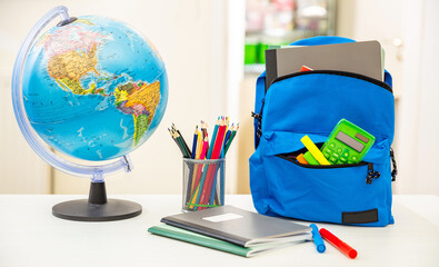 Wall Mural - Back to school. Student backpack and supplies on white desk