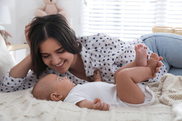 Wall Mural - Mother with her cute baby on bed at home