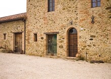 The Facade Of A Rural Stone Farmhouse With Wooden Doors And Windows In The Italian Countryside (Tuscany, Italy, Europe)