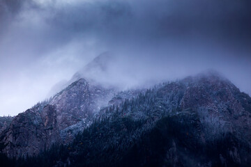 Wall Mural - Mountain peaks at  dawn with fog.